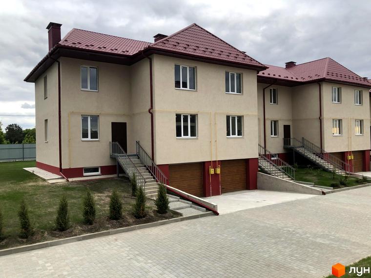Котеджне містечко КМ Горобиновий маєток. Зовнішній вигляд двоповерхових будинків з червоним дахом та прибудинкова територія з бруківкою та зеленими насадженнями.