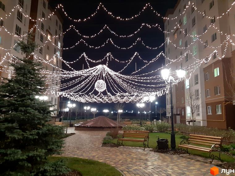 Житловий комплекс Львівський маєток з новорічною ілюмінацією. Прибудинкова територія прикрашена ялинкою та лавками.
