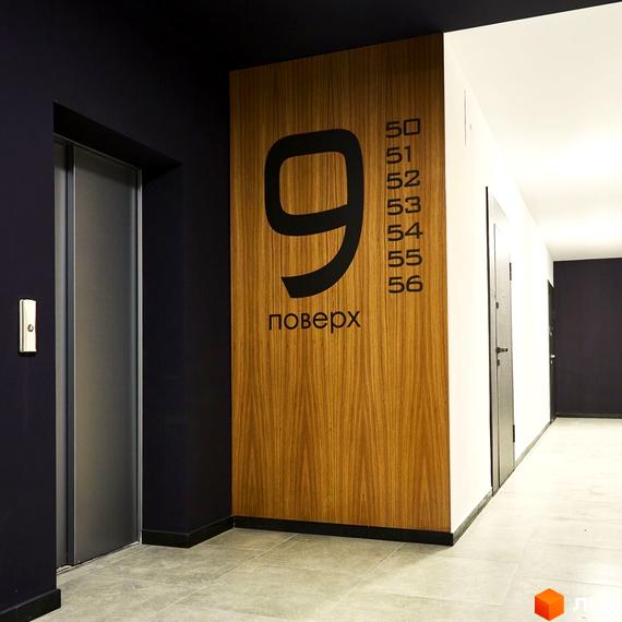 9 поверх ЖК OBRIY: сучасний дизайн фасаду з дерев'яними елементами та великою цифрою 9. Коридор з дверима та номерами квартир.