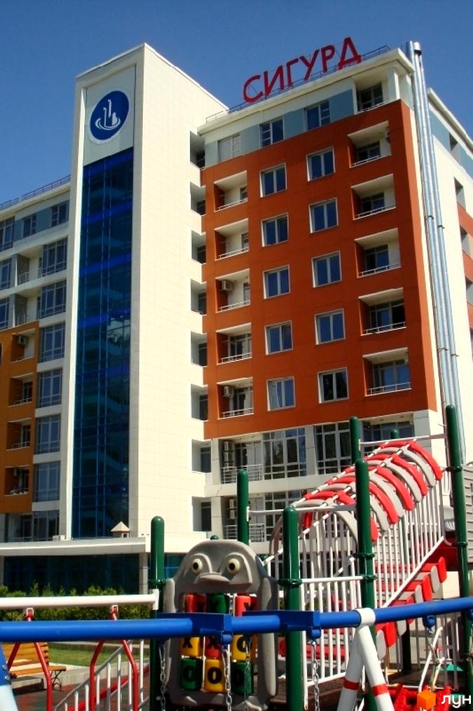 Житловий комплекс Сігурд Холл з яскравими фасадами та прибудинковою територією з дитячим майданчиком.