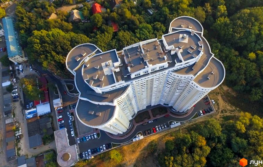 Житловий комплекс Сирецький Бояр з сучасною архітектурою та прибудинковою територією, оточений зеленими насадженнями.