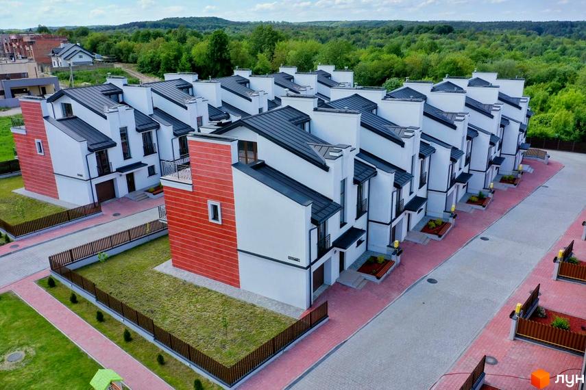 Ряд білих таунхаусів з темними дахами та червоними акцентними стінами в Таунхауси 