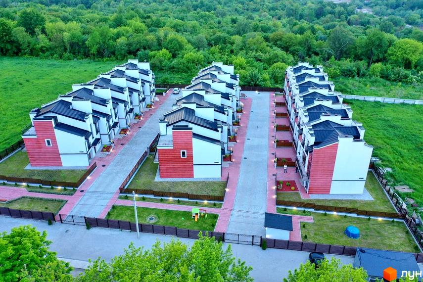 Фото таунхаусів у Житловому комплексі Raytman Park з висоти пташиного польоту. Вигляд на будинки з червоним оздобленням та зелену прибудинкову територію.