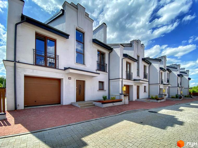 Зображення таунхаусів Raytman Park. Фасад будинку в світлих тонах, коричневі гаражні ворота, тротуарна плитка перед будинком.