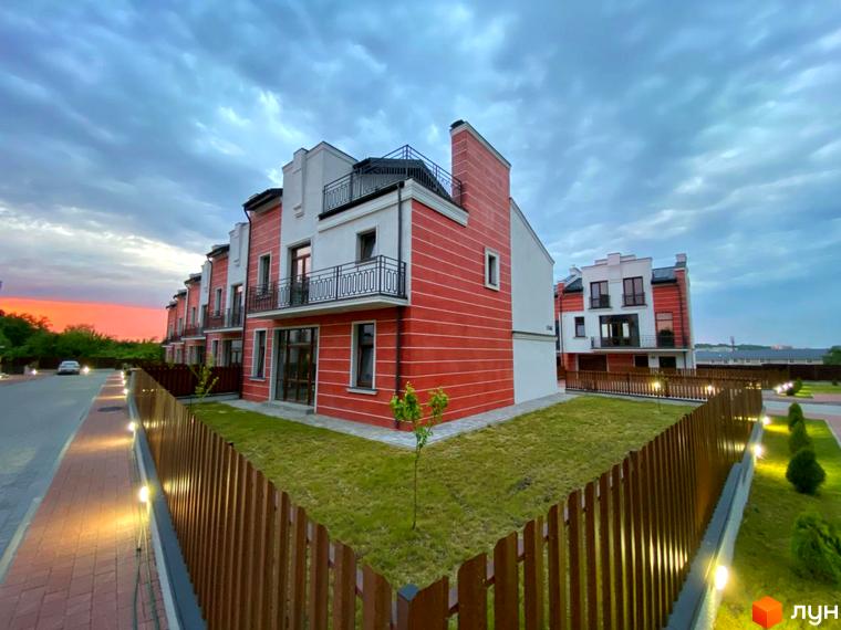 Таунхауси Raytman Park: фасади червоно-білого кольору, балкони з кованими перилами. Прибудинкова територія з газонами, дерев'яним парканом та вечірнім освітленням доріжок.