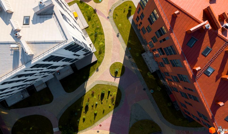 Комплекс Spectrum має будівлі з білими та помаранчевими фасадами. Територія включає доглянуті зелені зони та пішохідні доріжки.