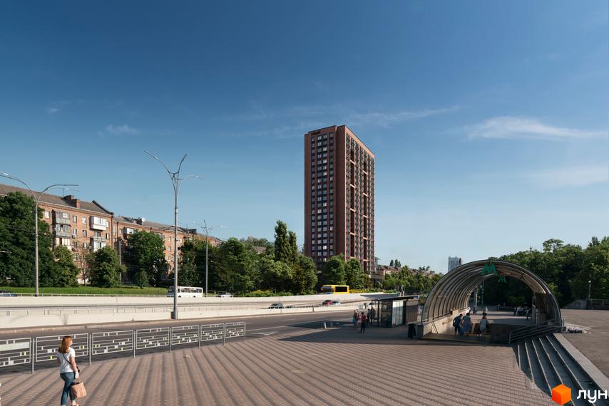Вид на цегляний житловий комплекс UNO City House з фасадом з вікон та балконів. Поруч розташована автобусна зупинка та вхід до метро.