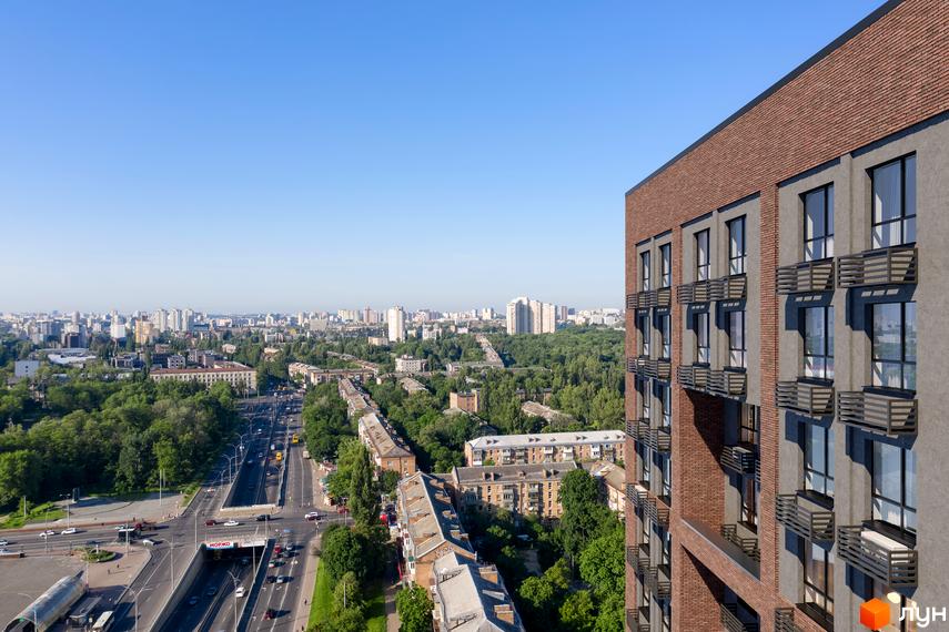 Вид на житловий комплекс UNO City House з цегляним фасадом та балконами. Навколо зелені дерева та міський пейзаж з багатоповерховими будинками.