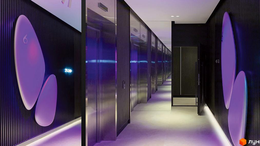 Комплекс Taryan Towers: коридор з ліфтами та декоративними елементами на стінах. Футуристичний дизайн з неоновим освітленням.