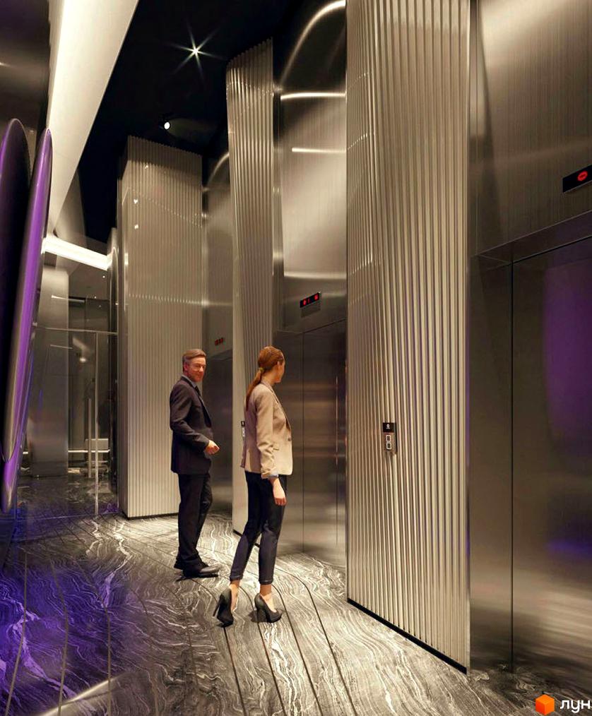 Інтер'єр житлового комплексу Taryan Towers з двома людьми біля ліфтів. Сучасний дизайн з металевими елементами та мармуровою підлогою.