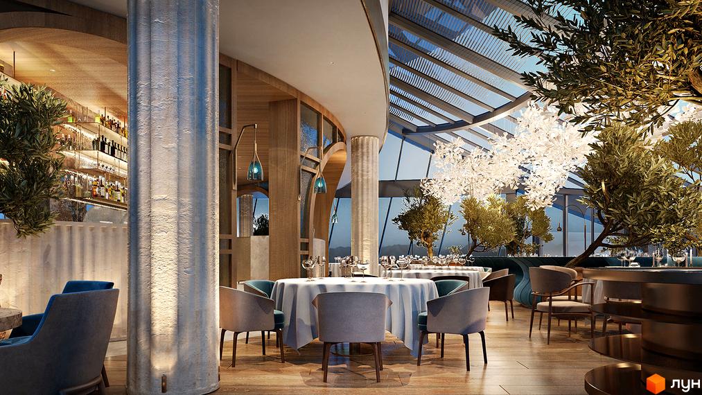 Інтер'єр ресторану в житловому комплексі Taryan Towers з колонами, деревами та скляним дахом. Затишні столики з білими скатертинами та кріслами запрошують до відпочинку.