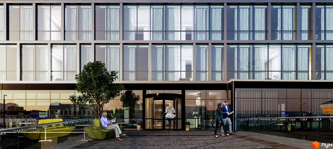 Багатоповерховий будинок Апарт-комплексу Times зі скляним фасадом та великими вікнами. Перед входом облаштована територія з деревом, зеленими лавками та людьми.