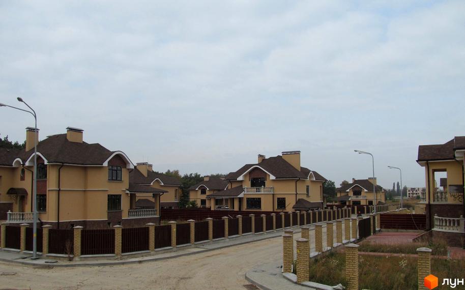 Зображення Котеджного містечка FEOFANIA COTTAGE: вид на нові будинки з коричневими дахами та світлими фасадами. Навколо будинків огорожі та доглянута територія.