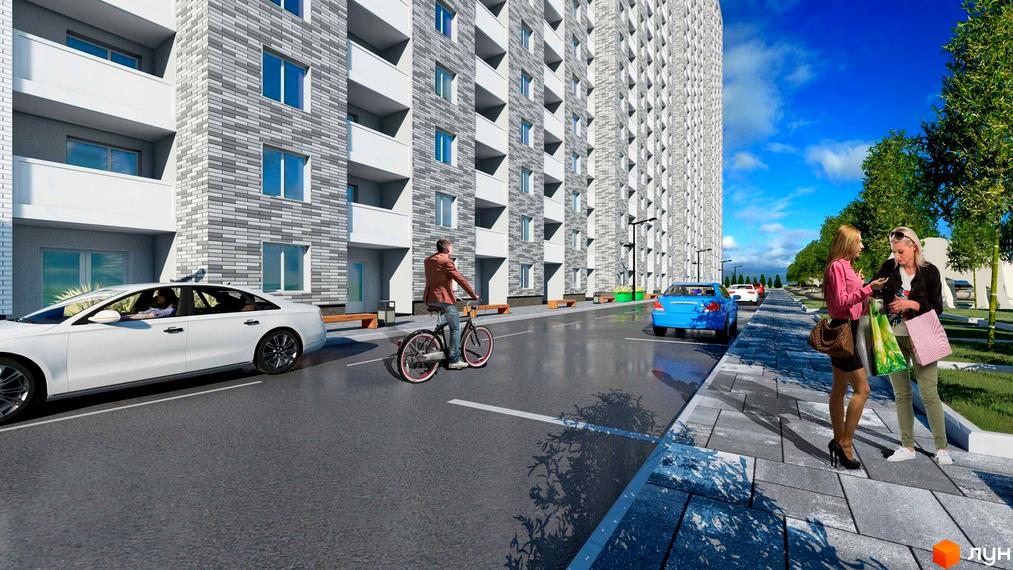 Житловий комплекс Ревуцький: фасади будинків з сірої цегли, балкони, дорога з автомобілями та пішохідна зона з деревами. Зовнішній вигляд новобудови та прибудинкової території.