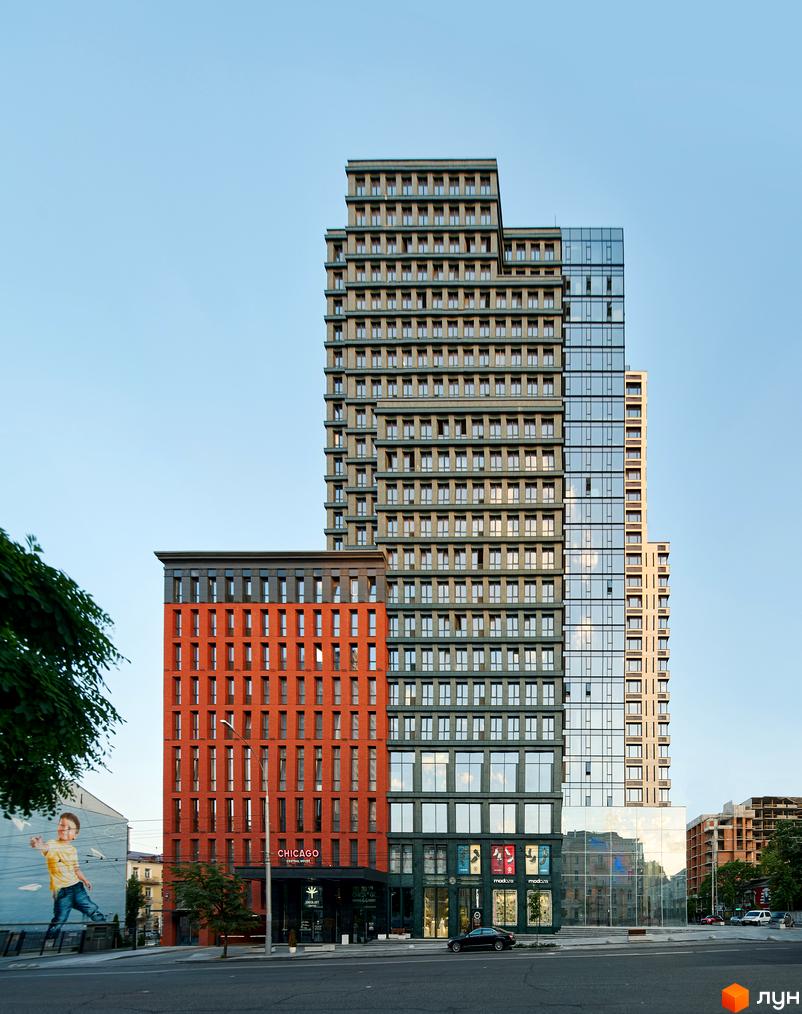 Житловий комплекс Chicago Central House. Високоповерхові будинки з різним дизайном фасадів: цегляний, скляний та сірий. На першому поверсі розташовані магазини та вхід до будівлі.