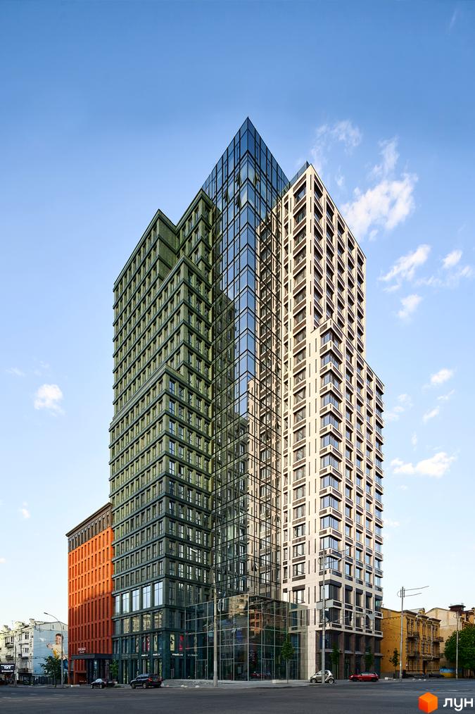 Висотна будівля ЖК Chicago Central House з скляним фасадом на фоні блакитного неба. На першому поверсі будівлі розташовані магазини, а перед будинком – дорога з автомобілями.