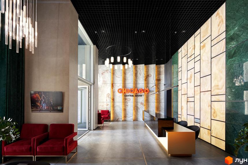 Інтер'єр холу Житлового комплексу Chicago Central House. Зона відпочинку з червоними кріслами та стійка рецепції.