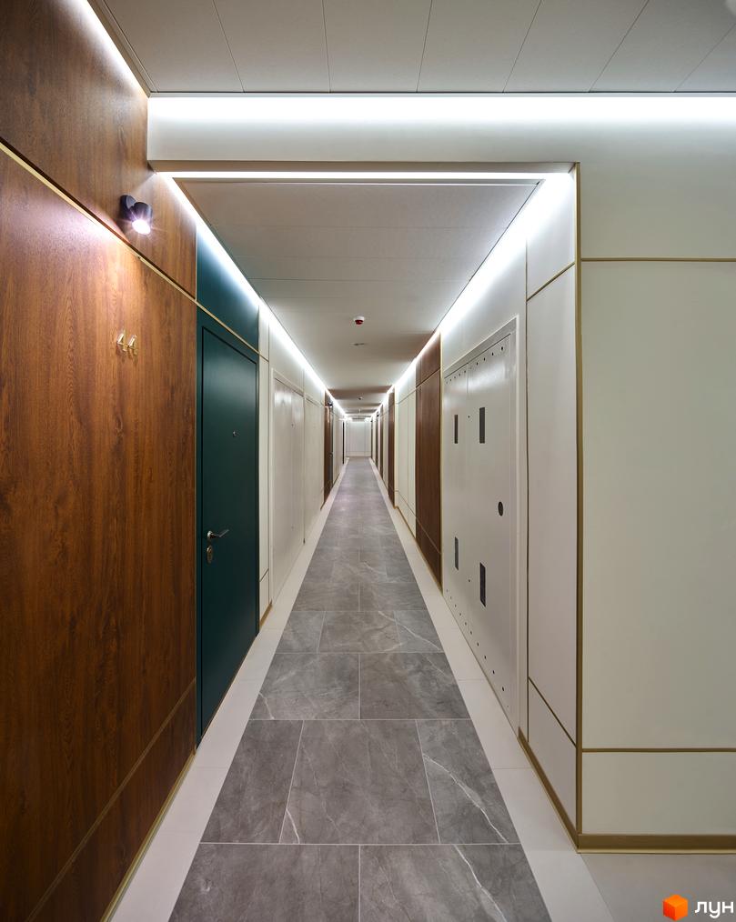 Коридор в ЖК Chicago Central House з оздобленням з дерева та світлодіодним освітленням. Сіра плитка на підлозі, двері з темним та світлим оздобленням.
