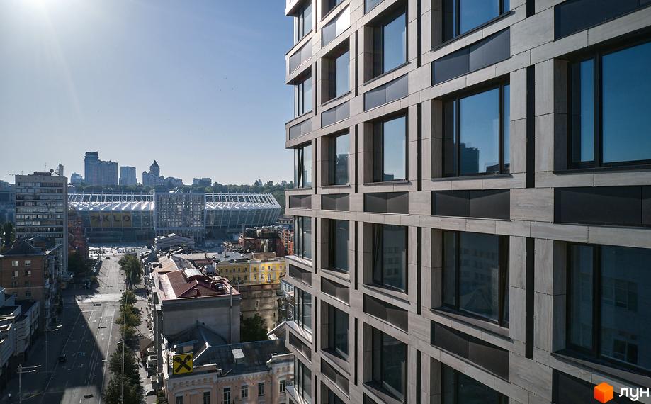 Вигляд на фасад та вікна Chicago Central House. На задньому плані видно місто та стадіон. Будівельний проєкт розташований у місті.