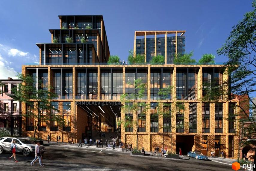 Багатоповерхова будівля БФК Ermolaev Center з цегляним фасадом та великими вікнами. Перед будівлею вулиця з пішоходами, автомобілями та зеленими насадженнями.