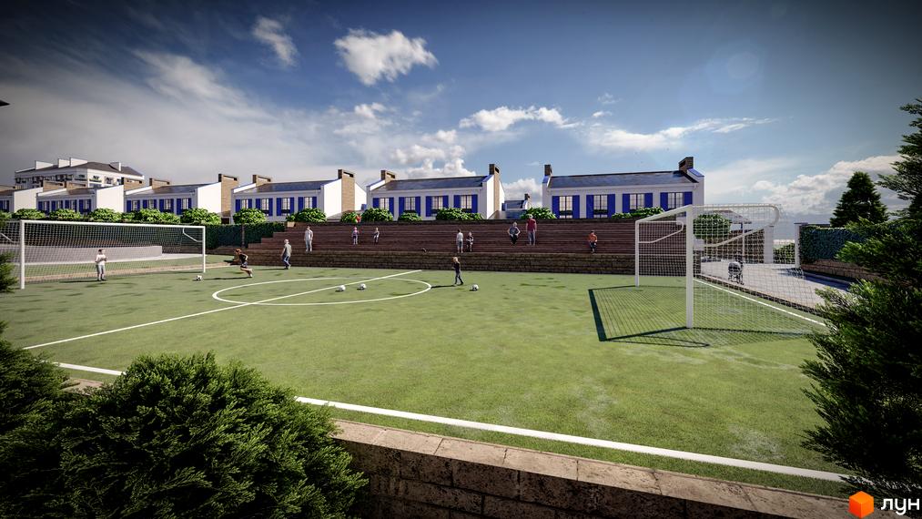 Зображення футбольного поля біля таунхаусів Club City. На задньому плані видно будинки з синіми віконницями та зелені насадження.