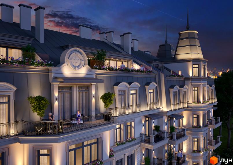 Клубний будинок „Консул“ з елегантною архітектурою та балконами, освітлений ввечері. Навколо зелені насадження та міський пейзаж.