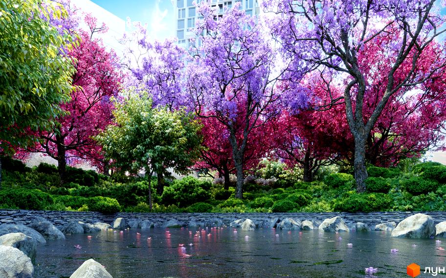 Житловий комплекс Creator City з багатою прибудинковою територією, що включає водойму та різнокольорові дерева. Навколо водойми розташовані камені та зелені насадження, що створюють атмосферу спокою.