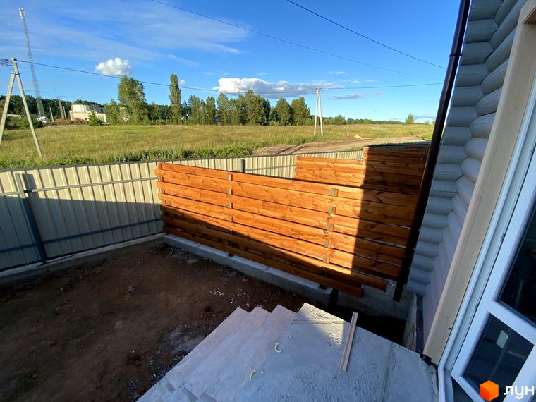 Зовнішній вигляд таунхауса LEVEL з дерев'яним парканом та прибудинковою територією. Благоустрій території, озеленення та ландшафтний дизайн.