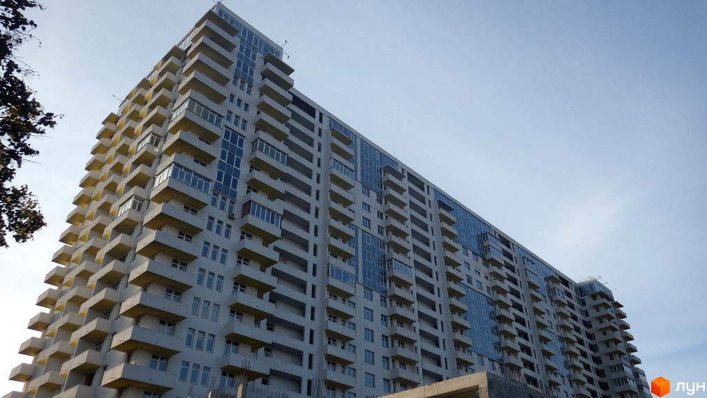 Житловий комплекс Перлина Нивок з сучасним фасадом та балконами. Прибудинкова територія з зеленими насадженнями.