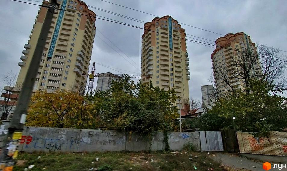 Житловий комплекс Три Богатирі з трьома висотними будинками та зеленими насадженнями на прибудинковій території.