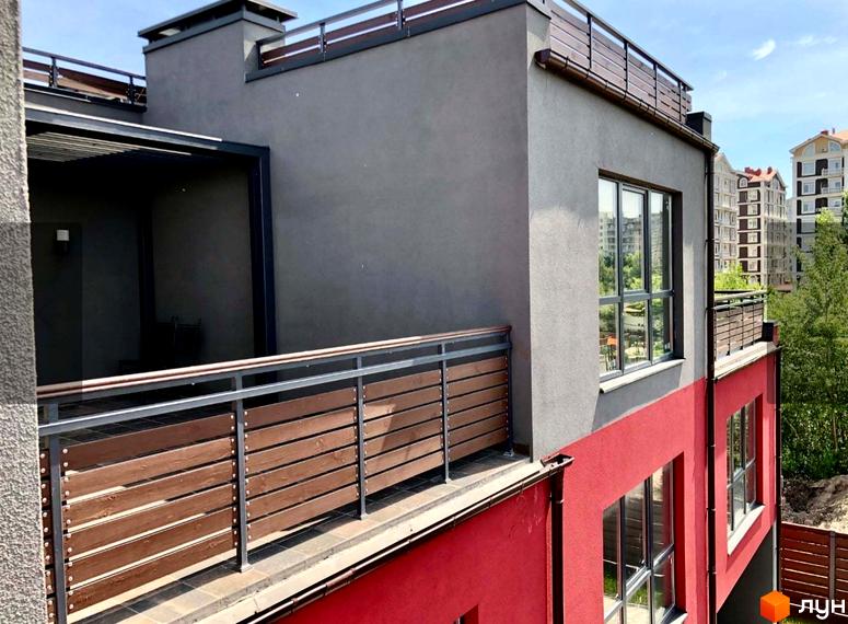 Таунхауси Old Stories з сірими та червоними фасадами, дерев'яними поручнями на балконах. На задньому плані видно інші будинки та дерева.