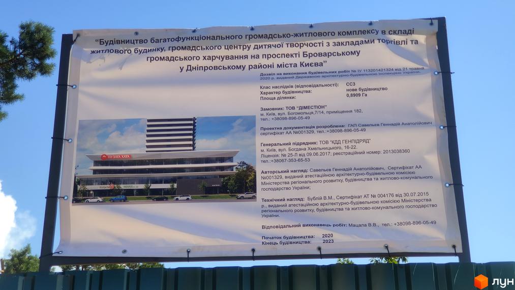 Новобудова на проспекті Броварському вражає скляним фасадом та виразною архітектурою, перед нею розташовані автомобілі.