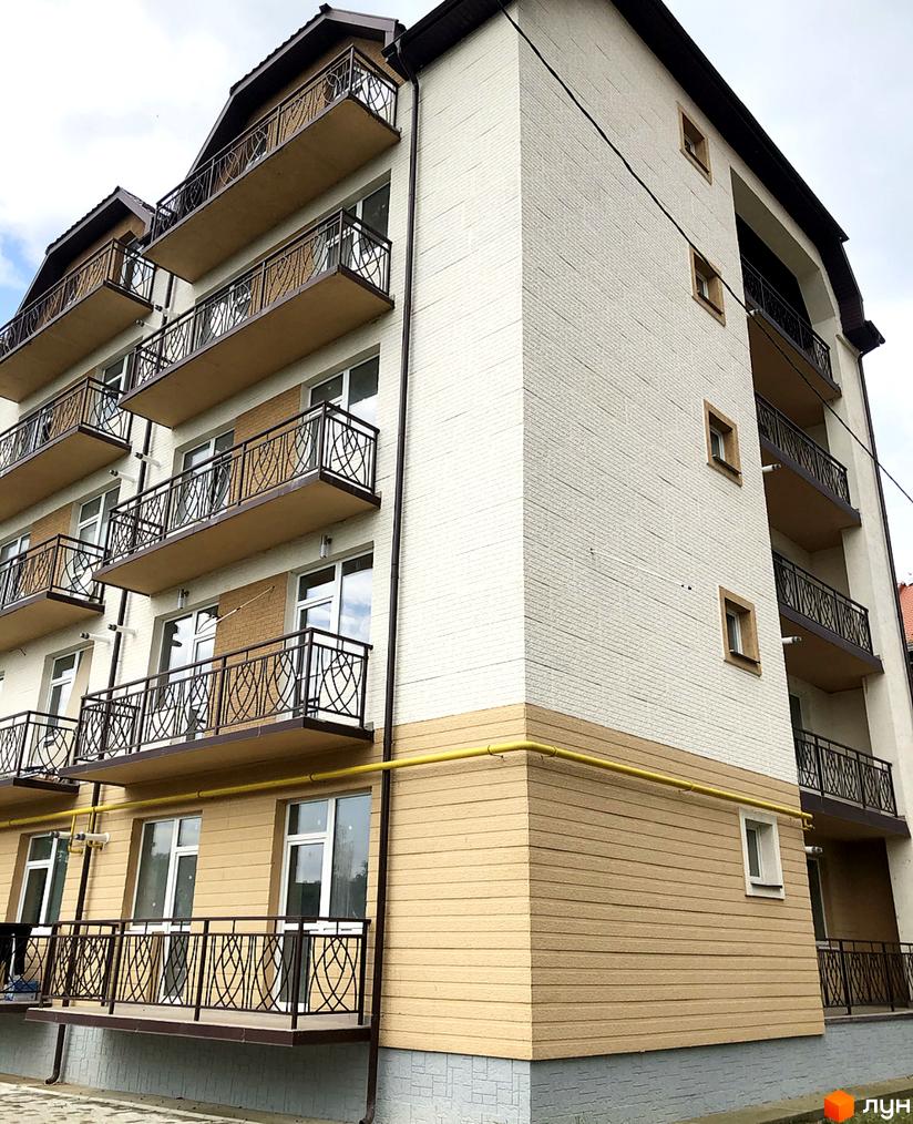 Зовнішній вигляд новобудови ЖК Котляревського з балконами та вікнами. Фасад будинку оздоблений світлою цеглою та бежевими панелями.