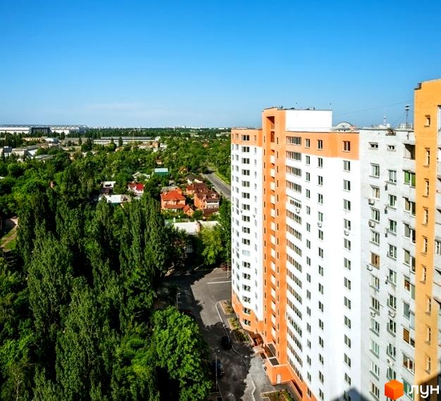 Житловий комплекс на вул. Кирила Розумовського, 19, з висотним будинком та зеленими насадженнями навколо.