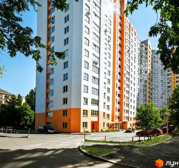 Житловий комплекс на вул. Кирила Розумовського, 19, з яскравими фасадами та прибудинковою територією, озелененою деревами.