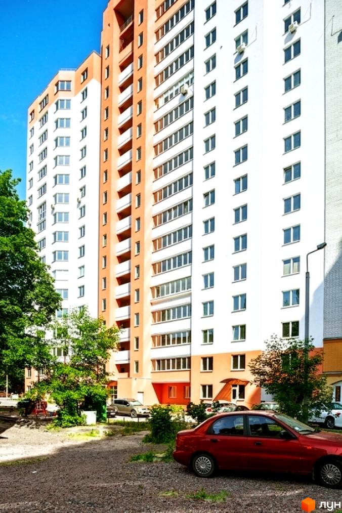 Житловий комплекс на вул. Кирила Розумовського, 19, з сучасним фасадом та прибудинковою територією, озелененою деревами.