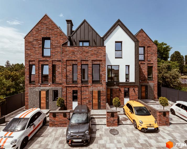 Котеджне містечко КМ Wunder Haus з цегляним фасадом та автомобілями на подвір'ї. Зовнішній вигляд будинків та прибудинкова територія.