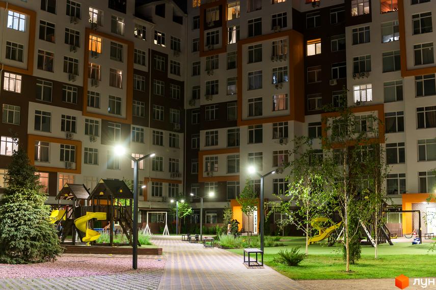Житловий комплекс Orange Park. Сучасна архітектура будівель та доглянута прибудинкова територія з дитячим майданчиком та зонами відпочинку.