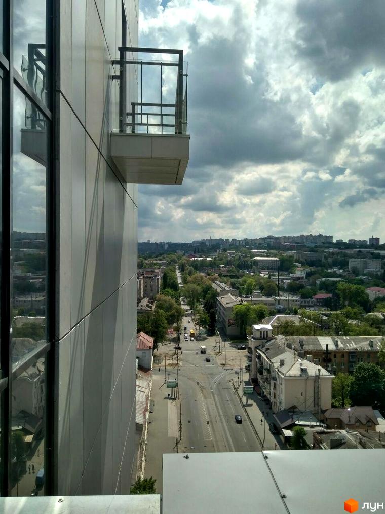 Вид на житловий комплекс Баку з фасаду будівлі та балкона. Навколо комплексу розташовані міські вулиці та багатоповерхова забудова.