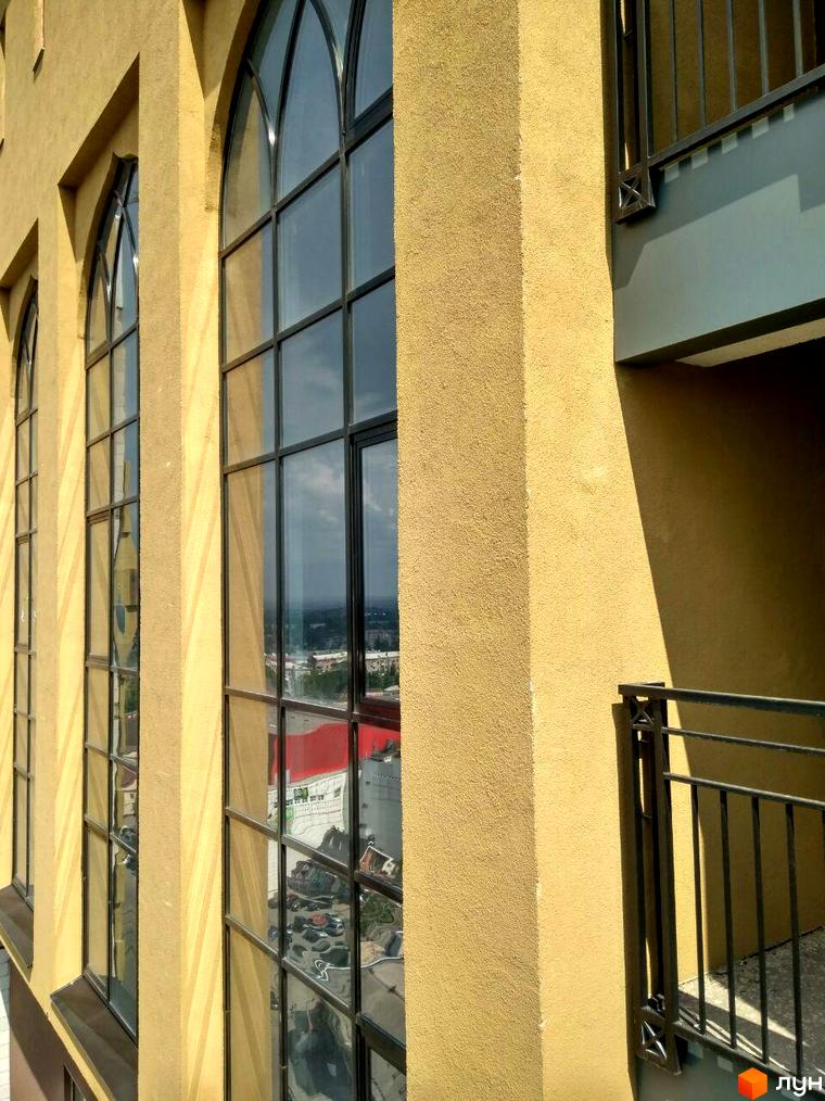 Житловий комплекс Баку. Будівля має жовтий текстурний фасад та великі арочні вікна. Наявний балкон з кованими елементами.