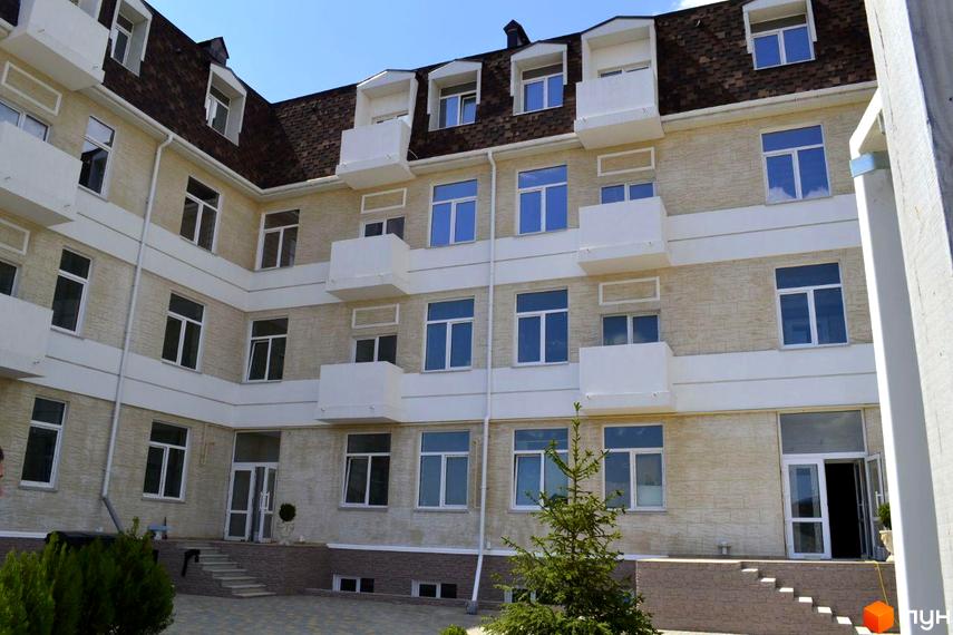 Житловий комплекс Малий Марсель-2. Зовнішній вигляд будівлі з численними вікнами та балконами, прибудинкова територія з деревами та сходами.
