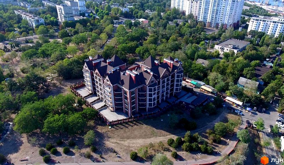 Житловий комплекс Клубна резиденція має багатоповерхову будівлю з оригінальними дахами та фасадами, оточену зеленими насадженнями та доглянутою територією.