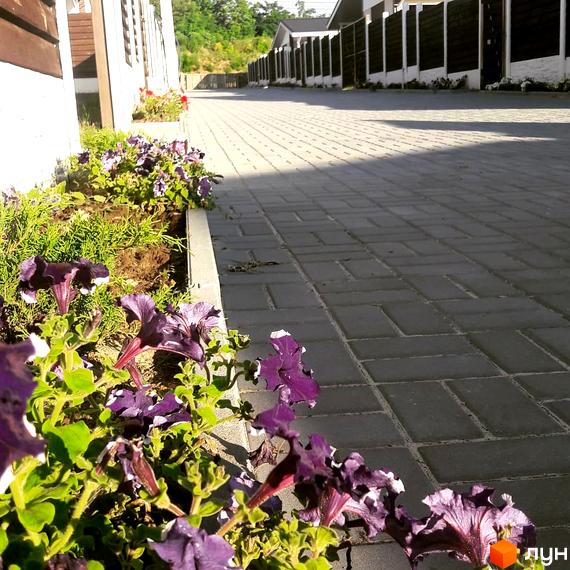 КМ Данилівський: фасади будинків та доглянута прибудинкова територія з квітковими клумбами та бруківкою. Огляд новобудови.