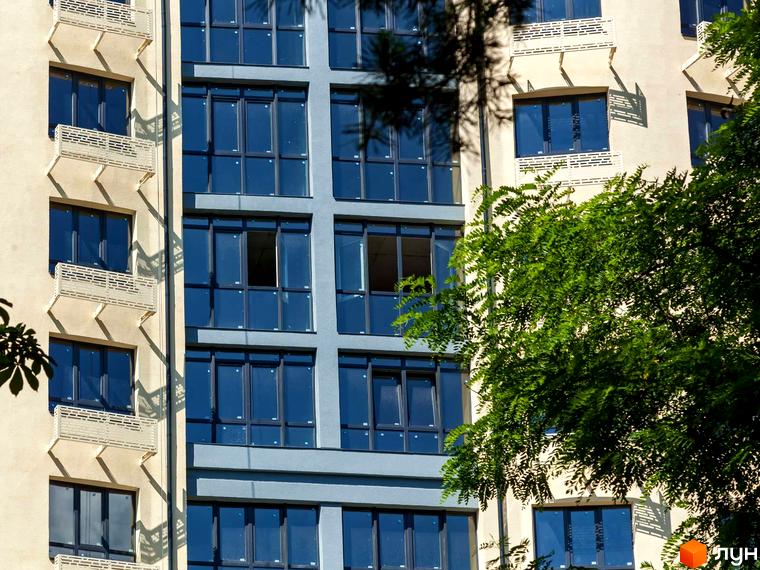 Житловий комплекс Royal Park: світлий фасад з балконами та сіра частина з великими вікнами. Поруч зелене дерево.