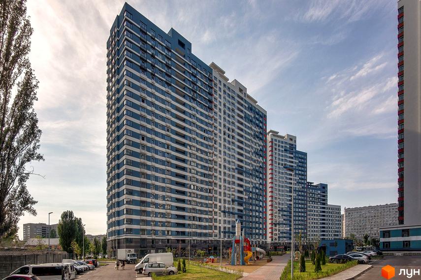 Житловий комплекс Галактика. Багатоповерхові будинки з синьо-білими фасадами та балконами. Поруч дитячий майданчик та парковка.