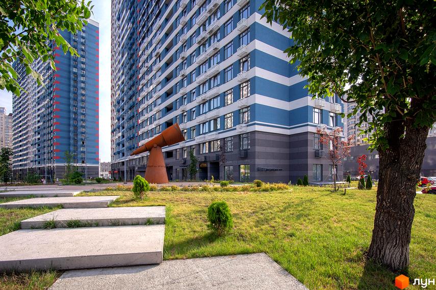 Житловий комплекс Галактика: двоколірні фасади, панорамні вікна, зелена прибудинкова територія з арт-об'єктом. Сучасна архітектура та комфортне життя.