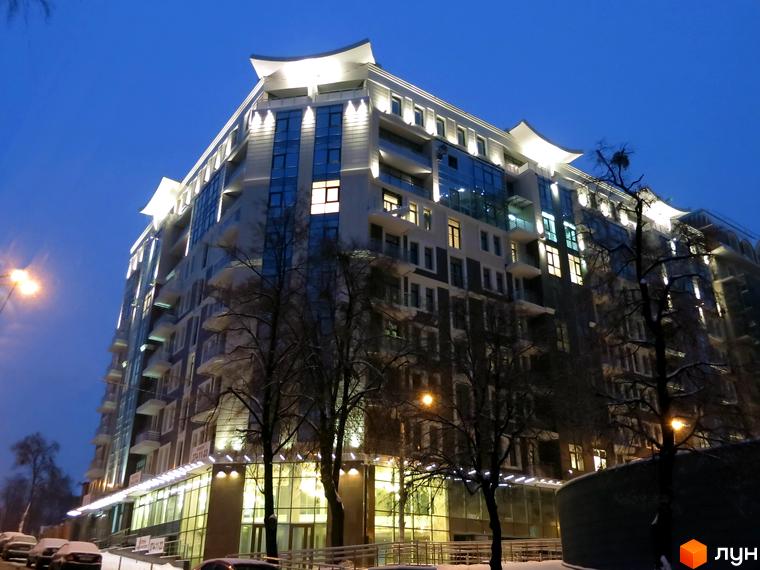 Житловий комплекс Zverinetskiy з сучасною архітектурою та освітленою прибудинковою територією в зимовий вечір.