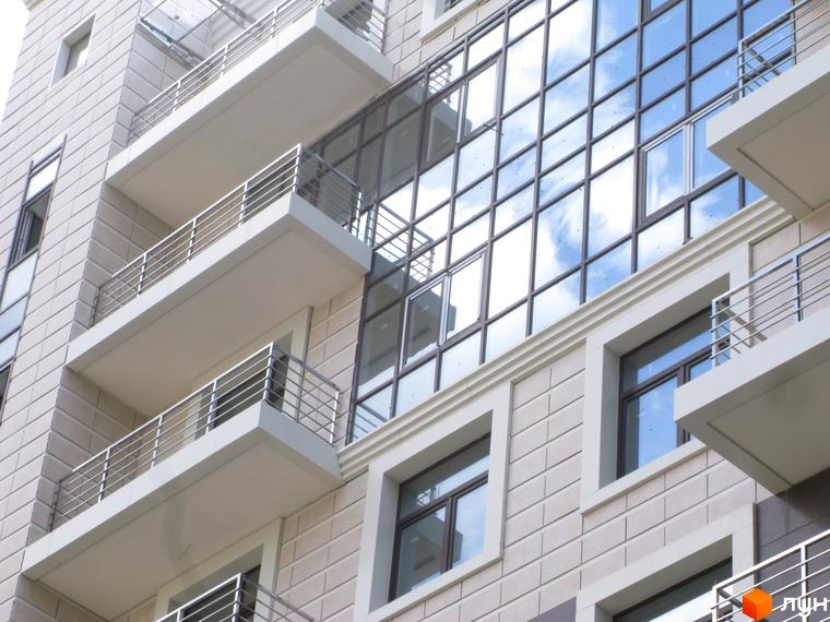 Фасад житлового комплексу Zverinetskiy з великими вікнами та балконами. Прибудинкова територія озеленена та облаштована.