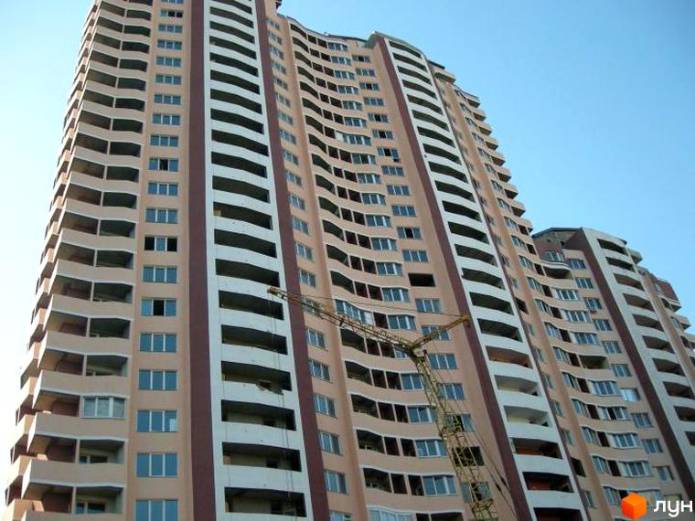 Житловий комплекс Стародарницький з сучасним фасадом та балконами. Прибудинкова територія з будівельною технікою.