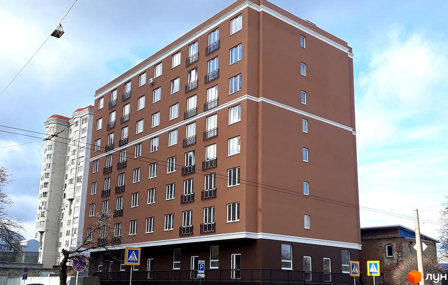 Зображення фасаду багатоповерхового будинку в Житловому комплексі Слов'янський. Вигляд новобудови з вікнами та балконами.